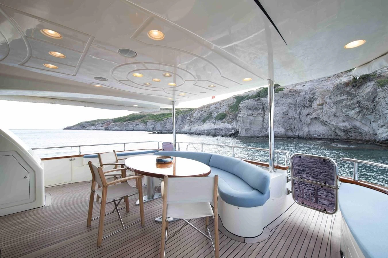 a table and chairs on a boat aboard STOLI Yacht for Sale