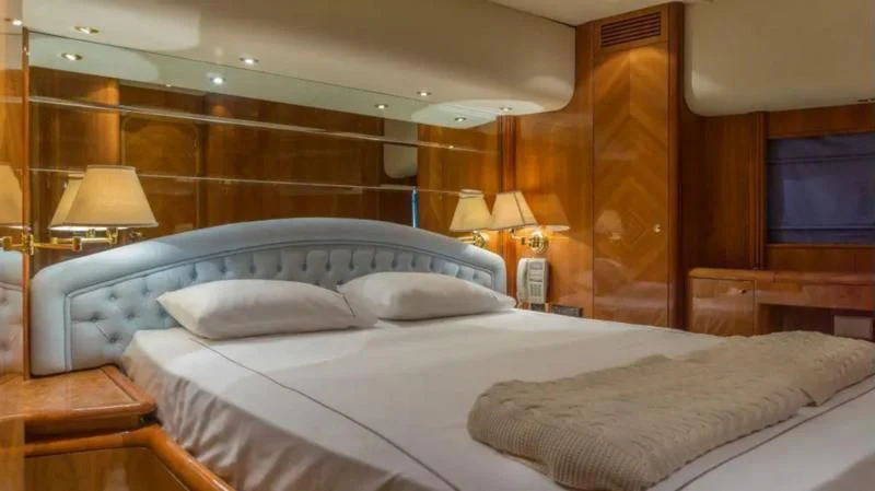 a room with a bed and a desk aboard STOLI Yacht for Sale