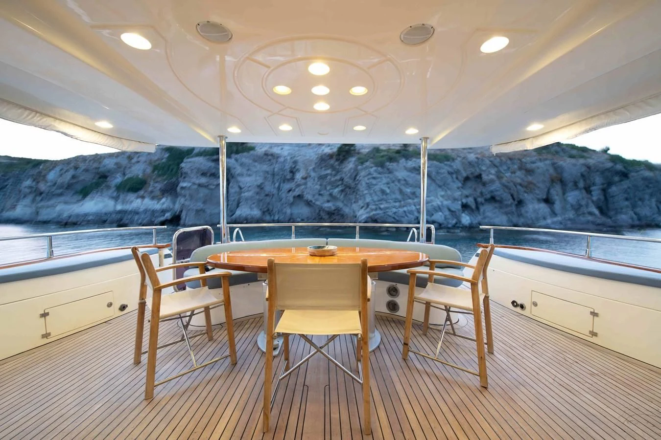 a dining table and chairs in a room with a large body of water aboard STOLI Yacht for Sale