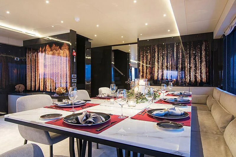 a large dining table with plates and glasses on it aboard MY EDEN Yacht for Sale