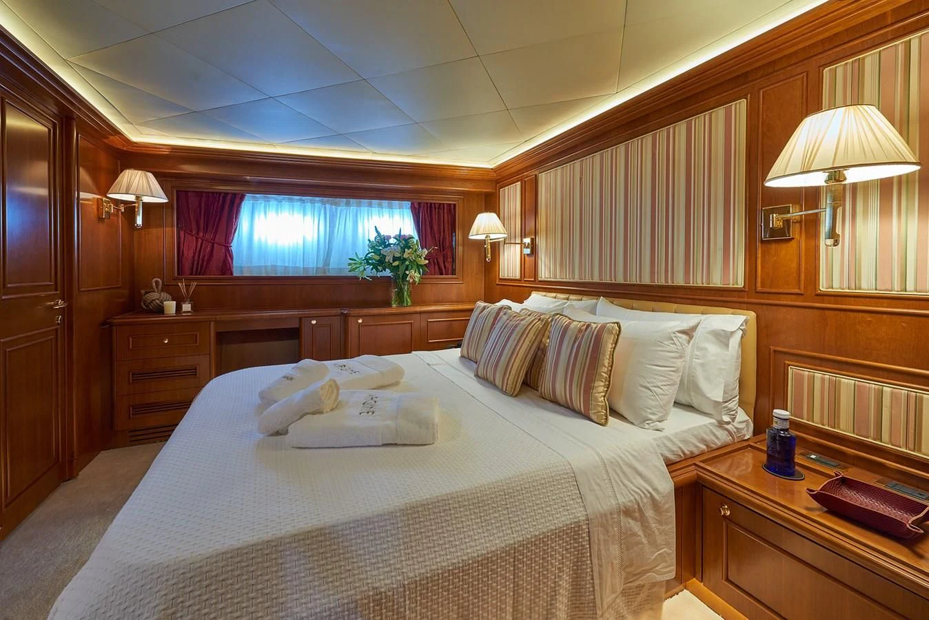 a bed with white sheets and pillows aboard IMAGINE Yacht for Charter