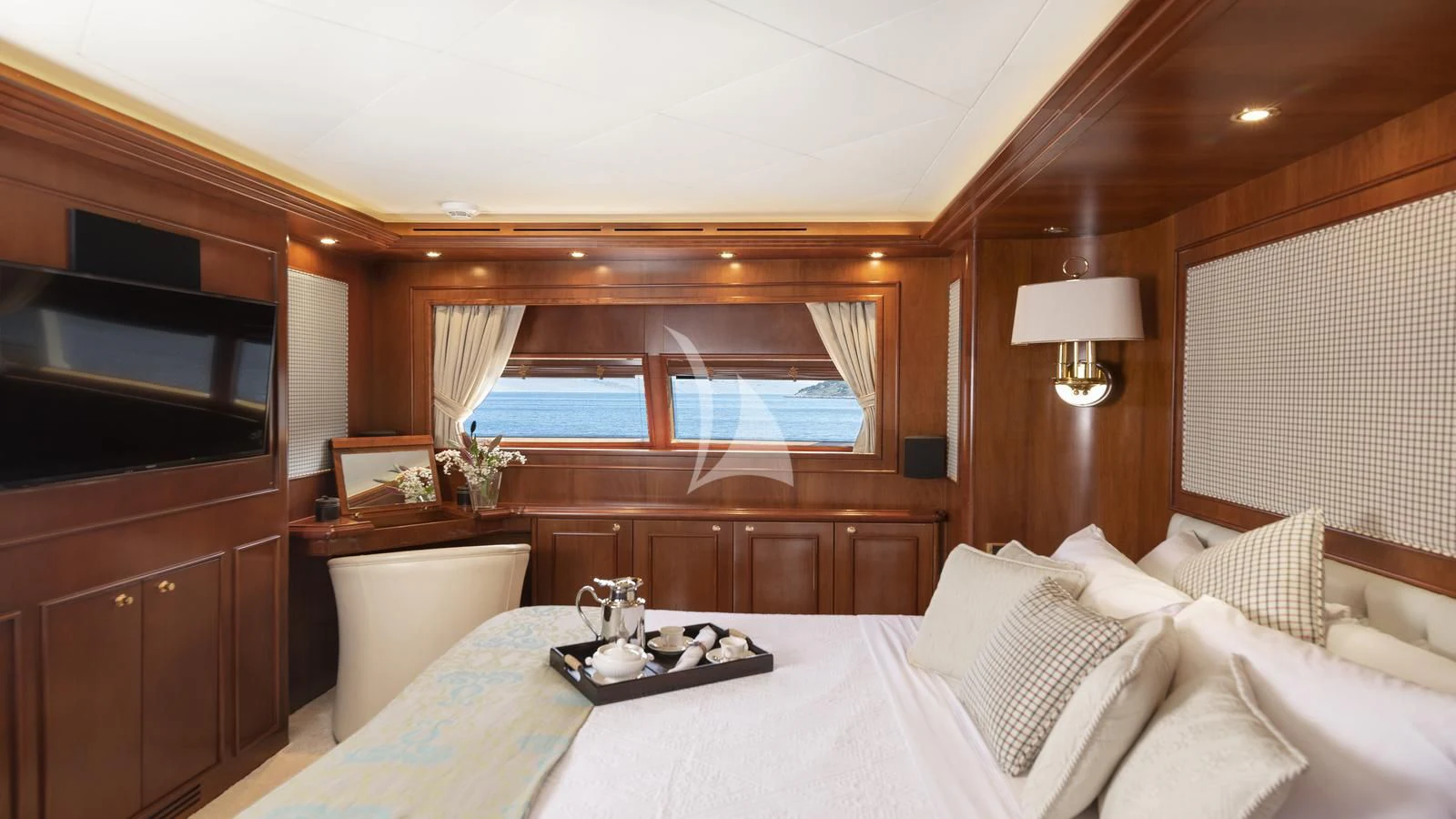 a bed with a white sheet and a television on the wall aboard IMAGINE Yacht for Charter