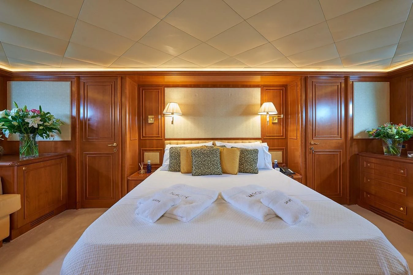 a large bed with white sheets aboard IMAGINE Yacht for Charter