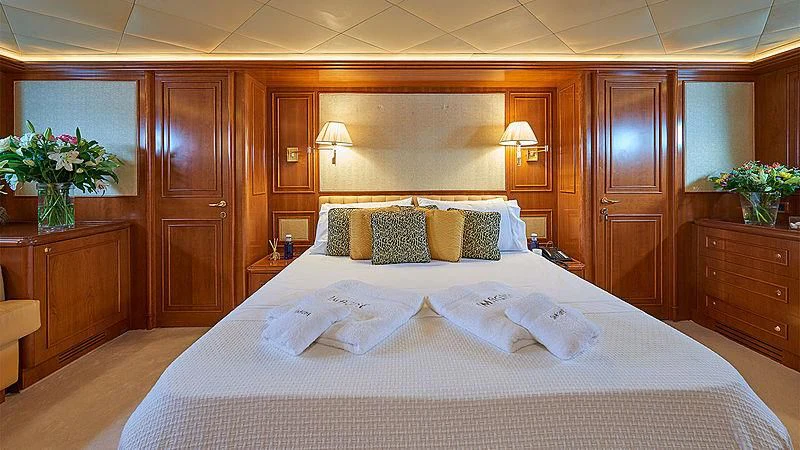 a bed with white sheets and pillows aboard IMAGINE Yacht for Charter