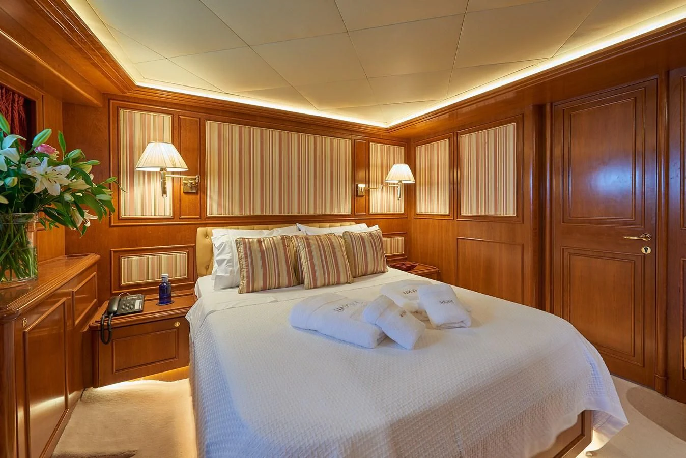 a room with a bed and a desk aboard IMAGINE Yacht for Charter