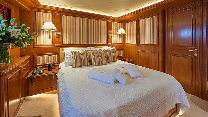 a bed with white sheets and pillows aboard IMAGINE Yacht for Charter