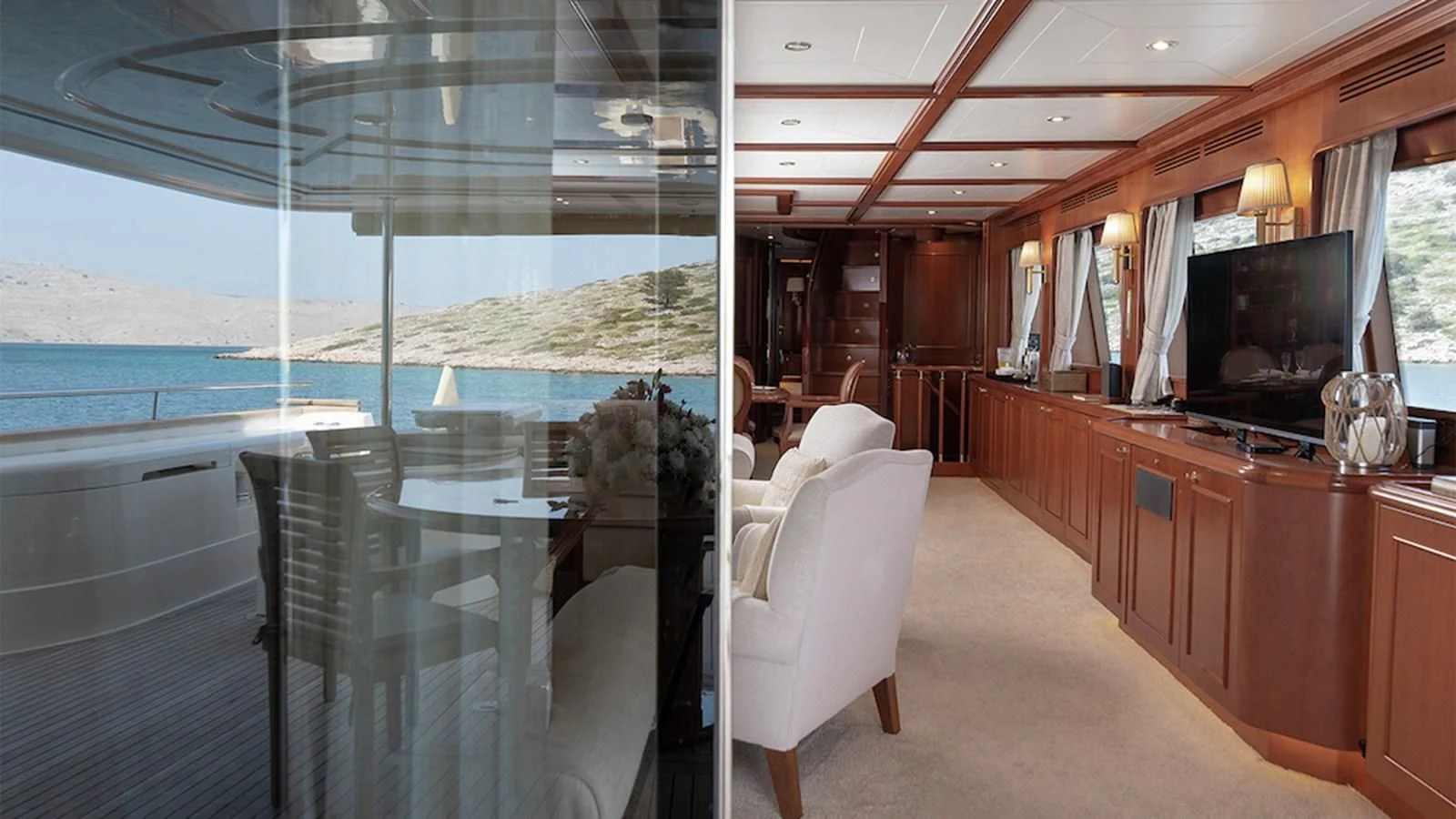 a room with a view of the ocean and a large television aboard IMAGINE Yacht for Charter