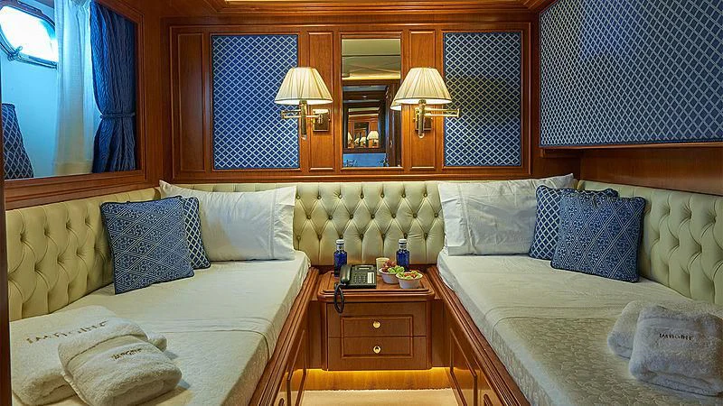 a room with two beds and a window aboard IMAGINE Yacht for Charter