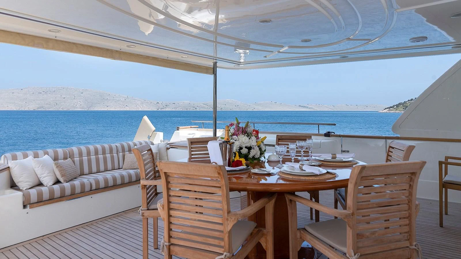 a table set for a meal on a deck overlooking the ocean aboard IMAGINE Yacht for Charter
