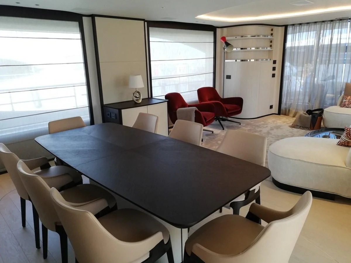 a large room with a table and chairs aboard UNDICI Yacht for Sale