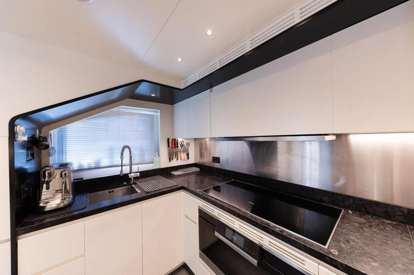 a kitchen with black counter tops aboard UNDICI Yacht for Sale