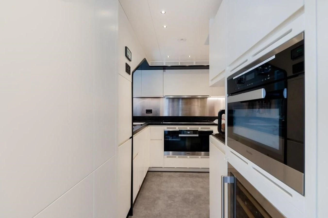 a kitchen with white cabinets aboard UNDICI Yacht for Sale