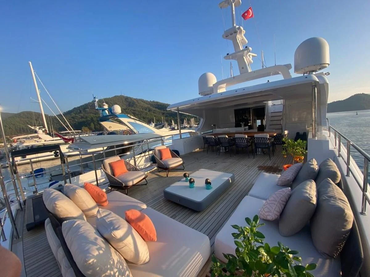 a deck with a pool and lounge chairs on it aboard UNDICI Yacht for Sale
