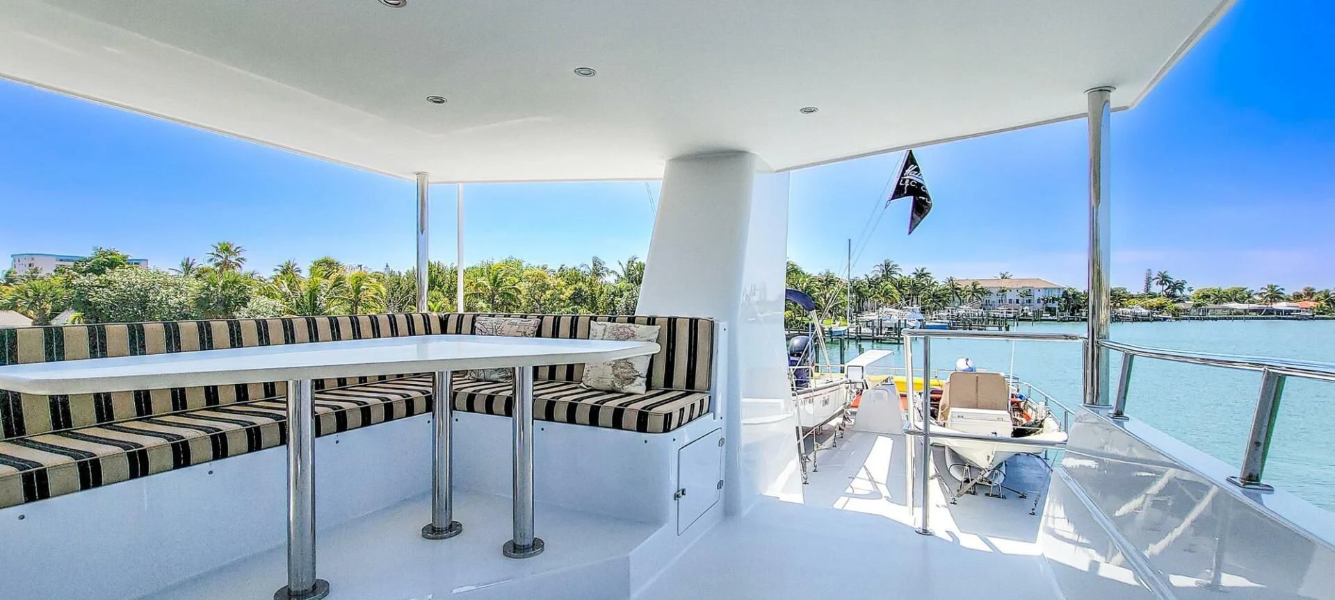 a covered patio with a table and chairs on it aboard IIWII Yacht for Sale