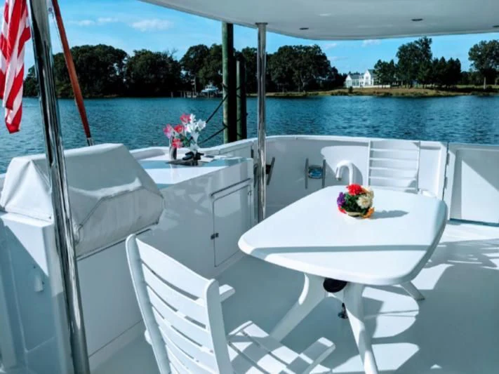 a table with chairs on it next to a body of water aboard IIWII Yacht for Sale