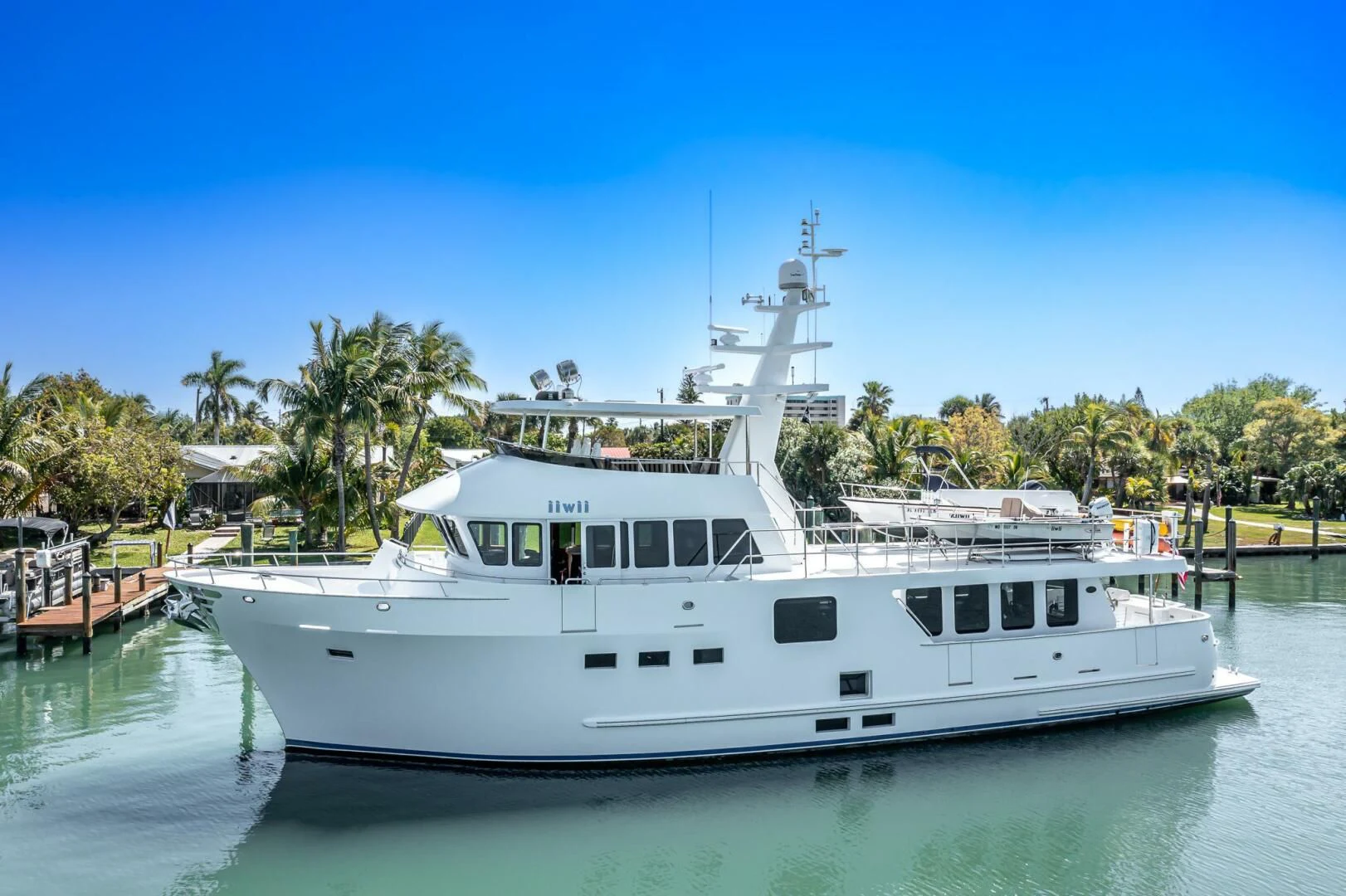 a white boat in a harbor aboard IIWII Yacht for Sale