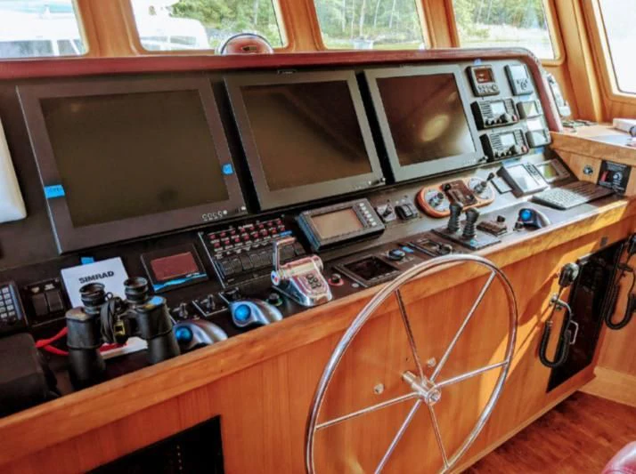 a computer desk with a large monitor aboard IIWII Yacht for Sale