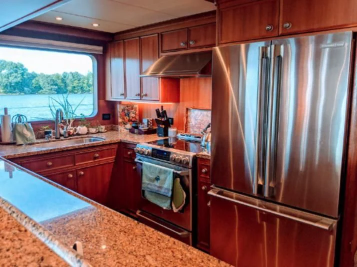 a kitchen with a stainless steel refrigerator aboard IIWII Yacht for Sale