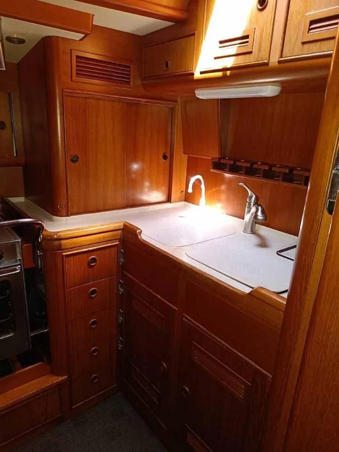 a kitchen with wooden cabinets aboard PLUM Yacht for Sale