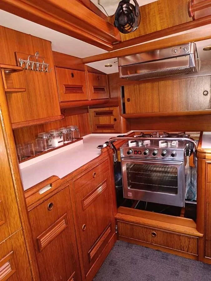 a kitchen with wooden cabinets aboard PLUM Yacht for Sale