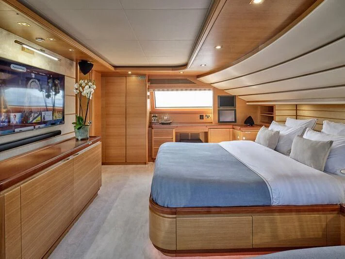 a bedroom with a bed and a tv aboard PAREAKKI Yacht for Sale
