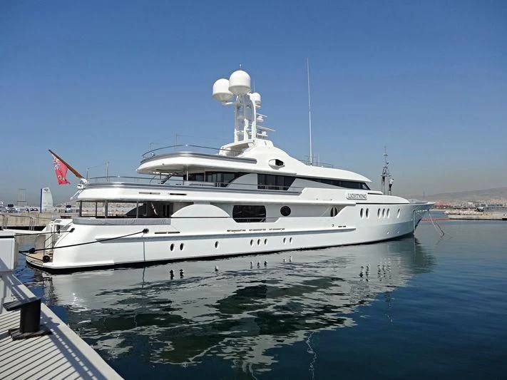 a large white boat in a harbor aboard LIGHTNING Yacht for Sale