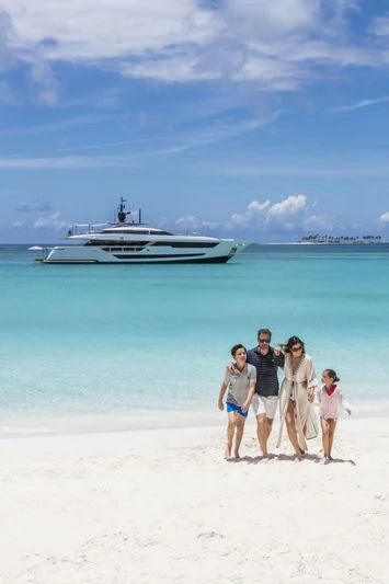 a family standing on a beach aboard NEVER BLUE Yacht for Sale