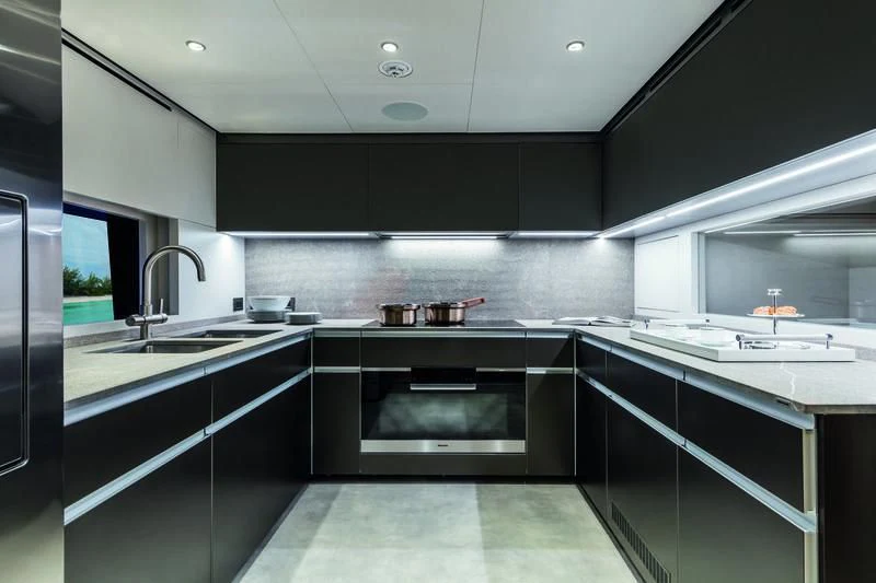 a kitchen with black cabinets aboard NEVER BLUE Yacht for Sale