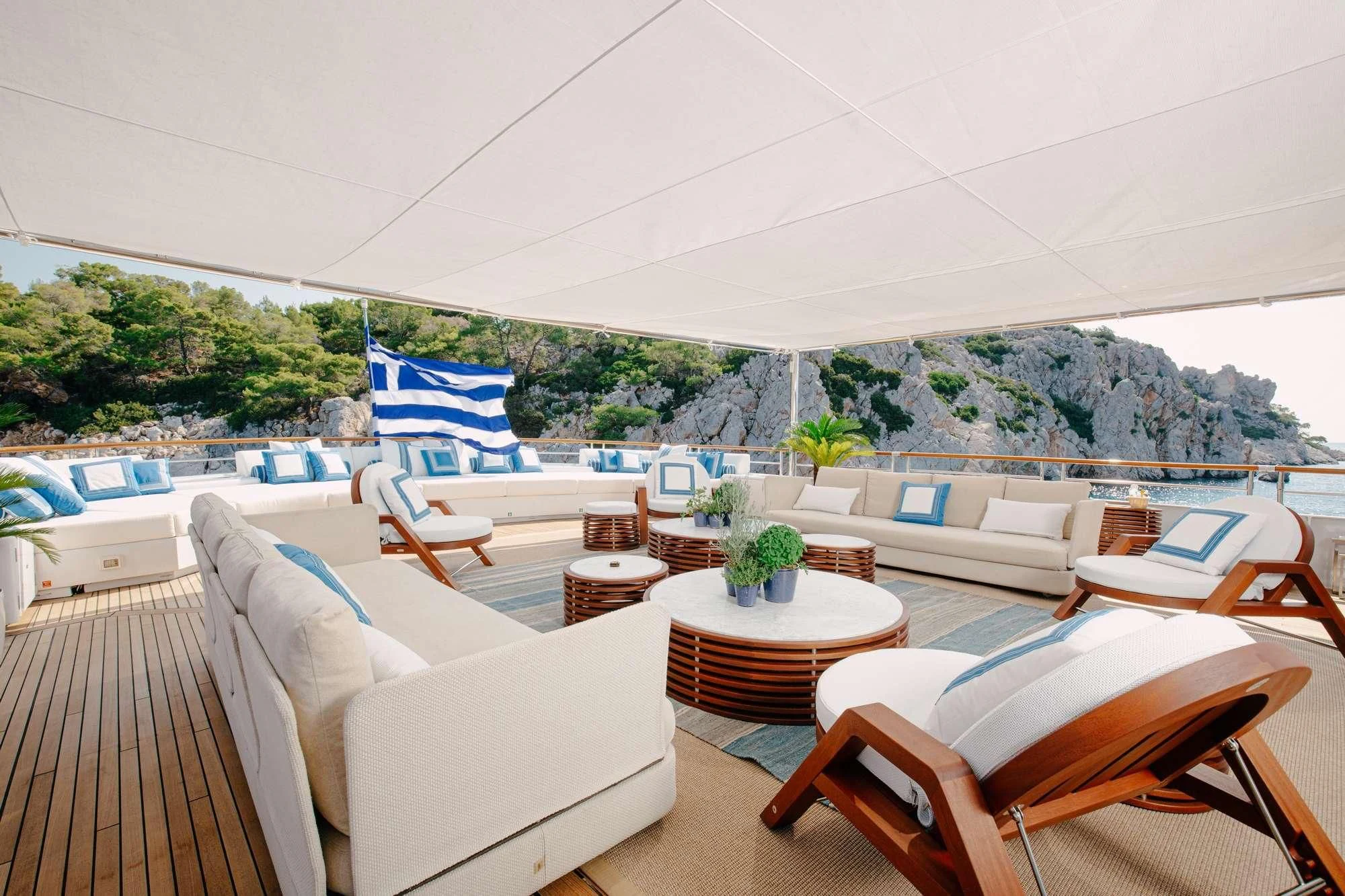 a room with a table chairs and a view of mountains aboard ITOTO Yacht for Charter