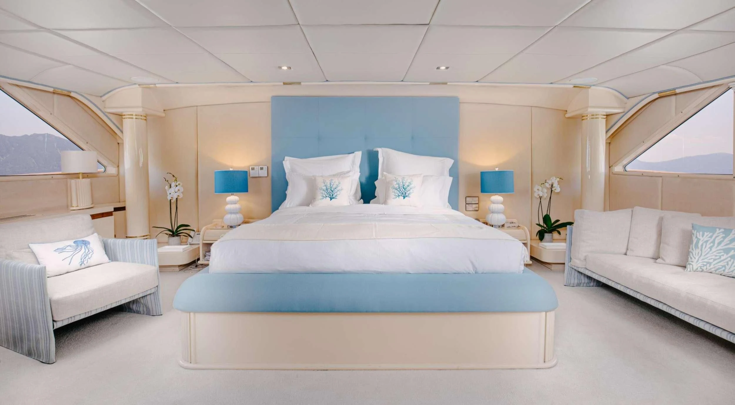 a modern bedroom with a blue bed aboard ITOTO Yacht for Charter