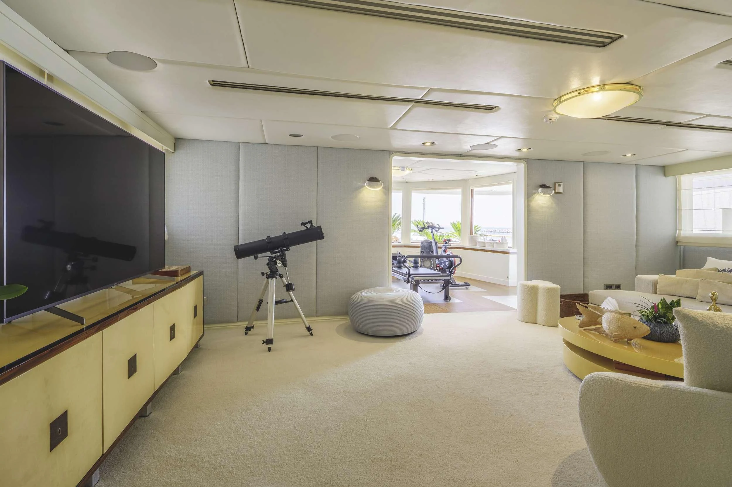 a room with a large television and a table and chairs aboard ITOTO Yacht for Charter