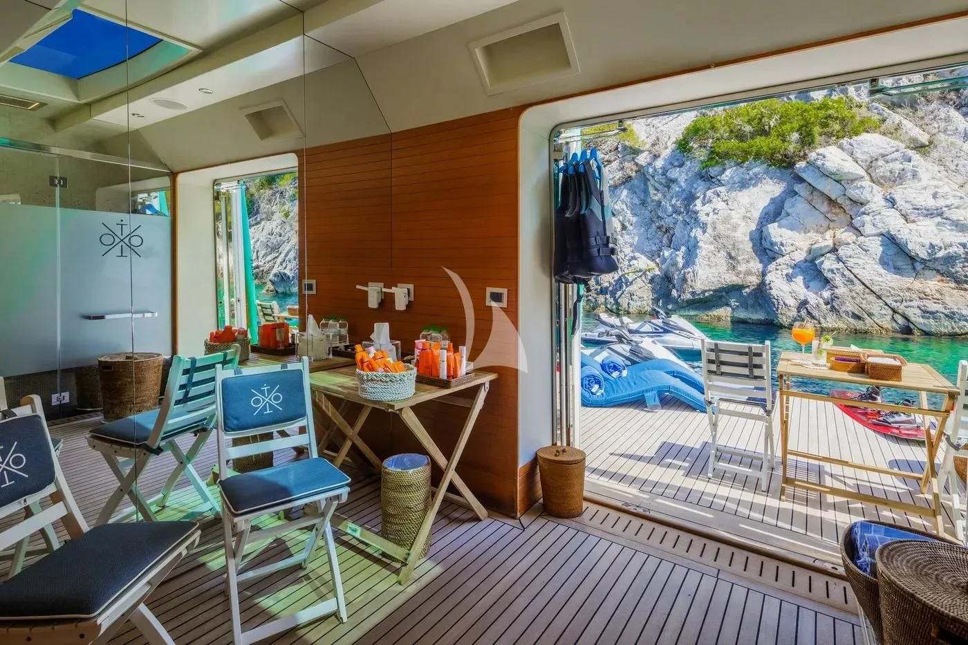 a room with a table chairs and a painting on the wall aboard ITOTO Yacht for Charter