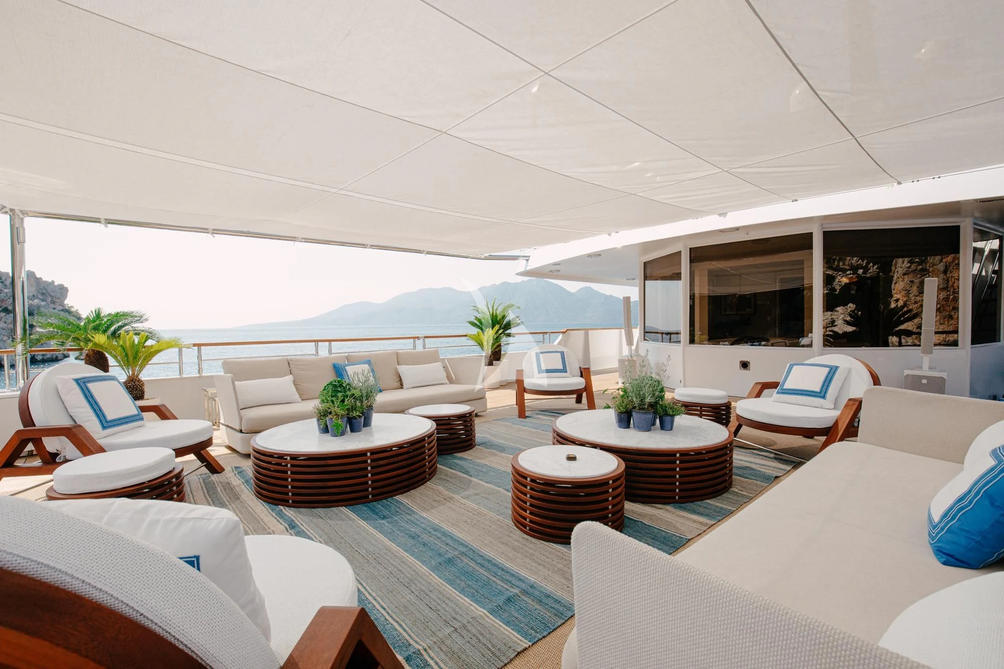 a room with a table chairs and a pool aboard ITOTO Yacht for Charter