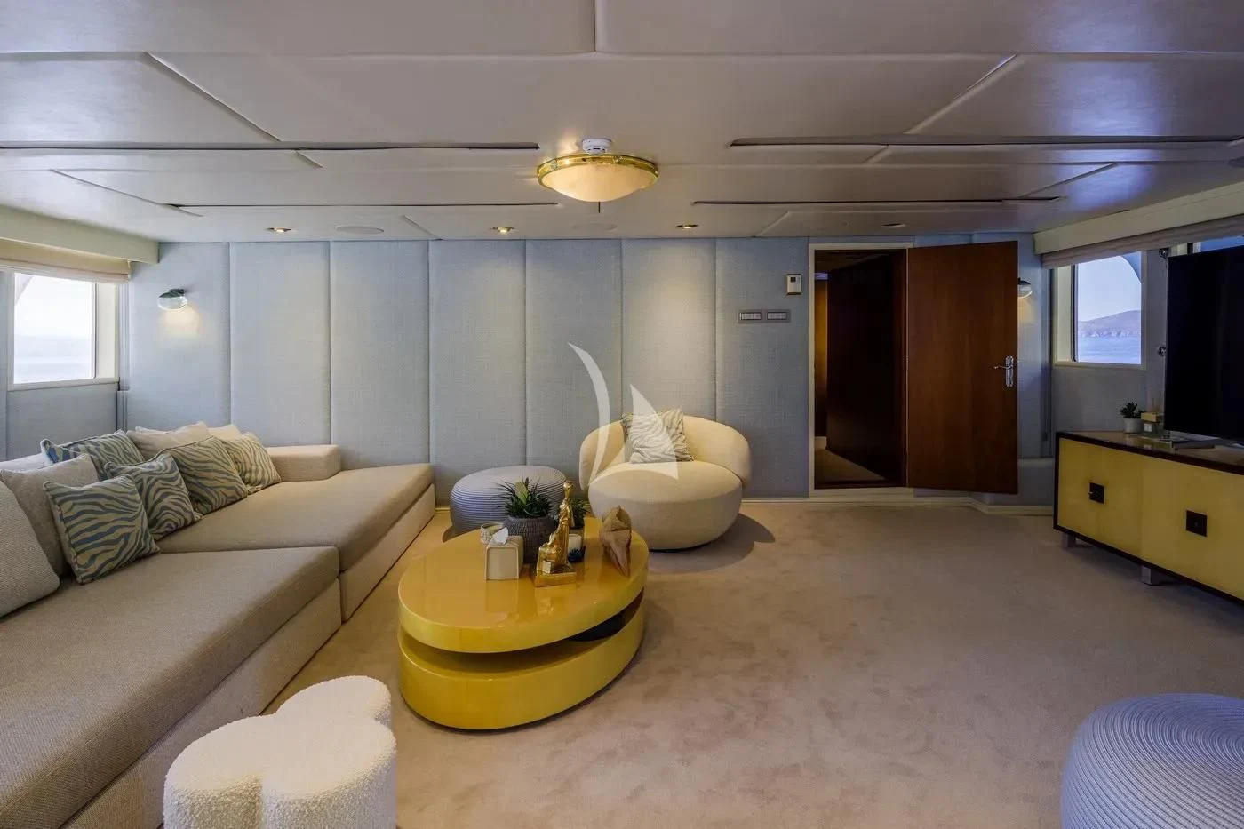 a living room with a yellow coffee table and a couch aboard ITOTO Yacht for Charter