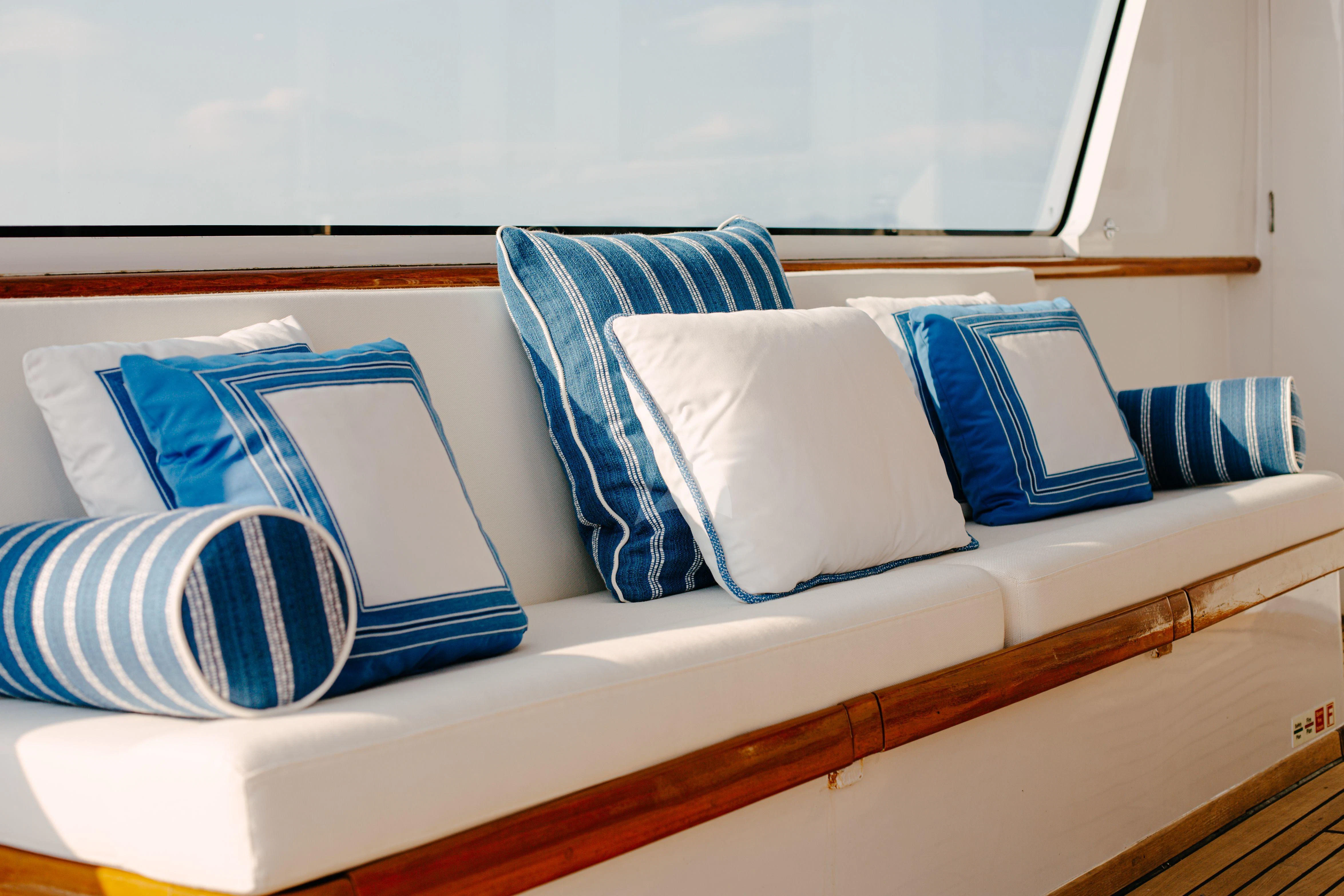 a bed with blue and white pillows aboard ITOTO Yacht for Charter