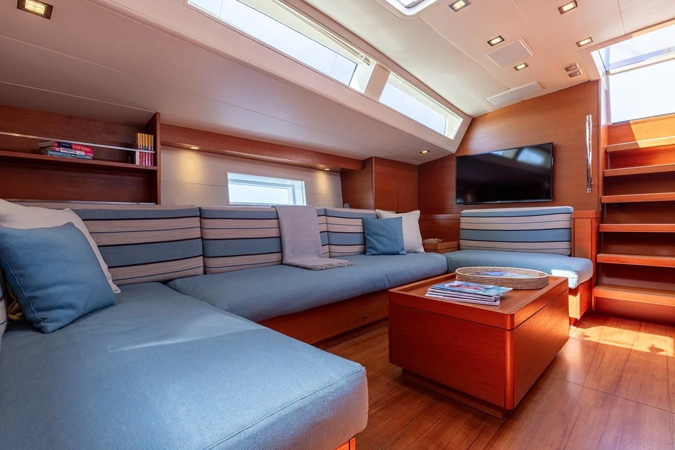 a living room with a blue couch aboard INTO THE SUNSET Yacht for Sale