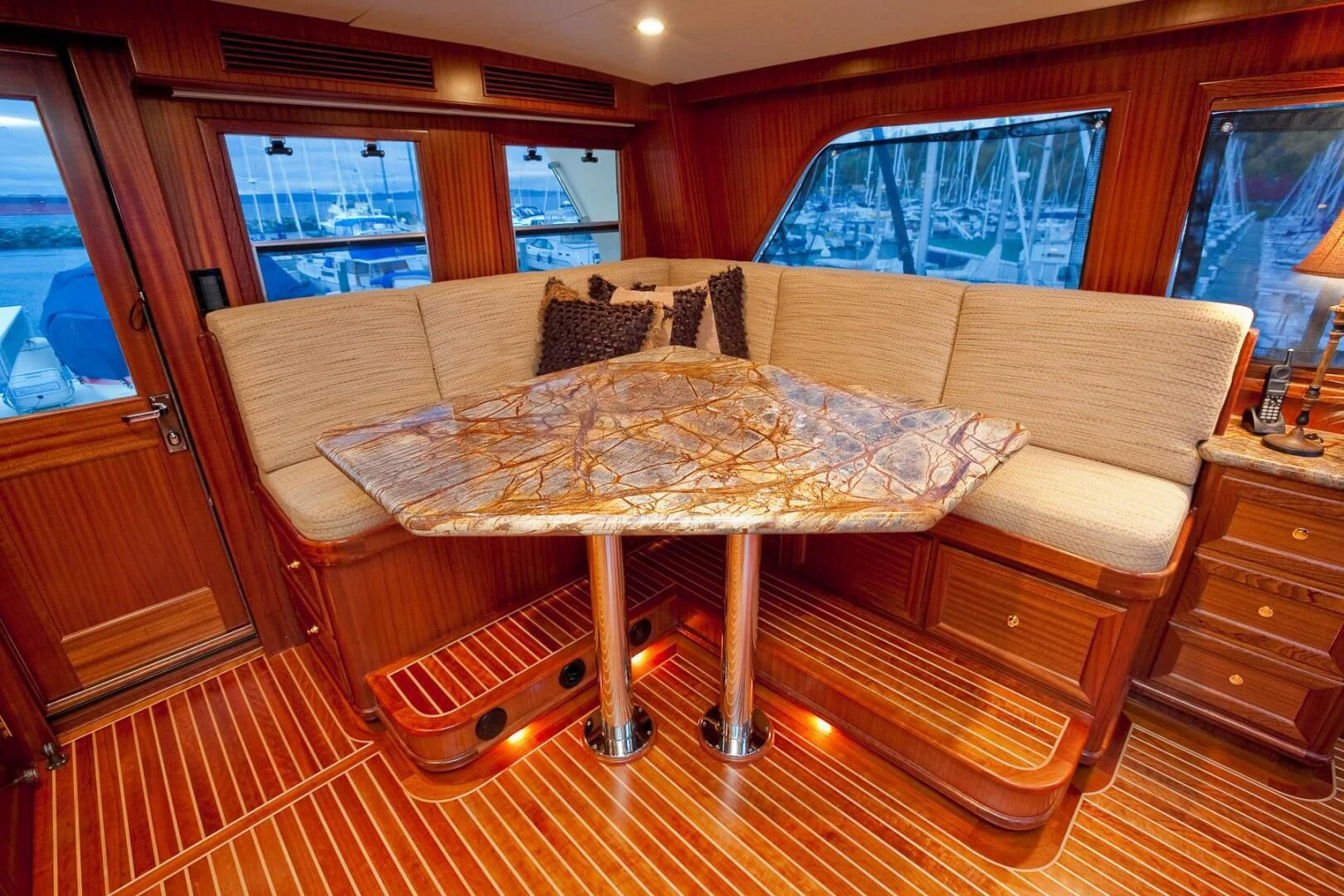 a table with a couch and a window in the background aboard AL DI LA Yacht for Sale