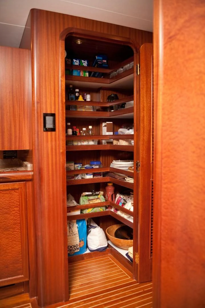 a wooden cabinet with shelves and items on it aboard AL DI LA Yacht for Sale