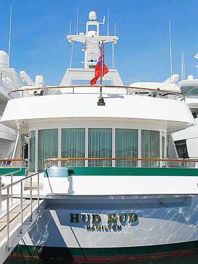 a large white boat with a red flag on the front aboard HUD HUD Yacht for Sale