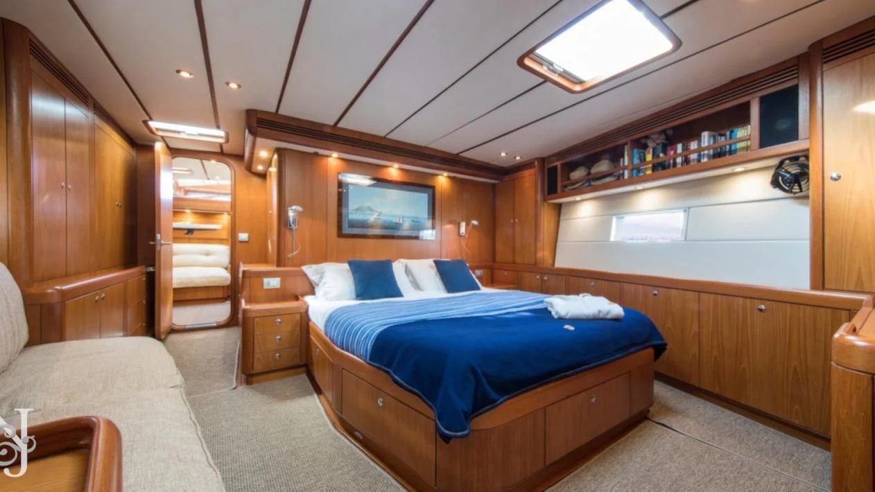 a bedroom with a bed and a bookcase aboard MEDUSA Yacht for Sale