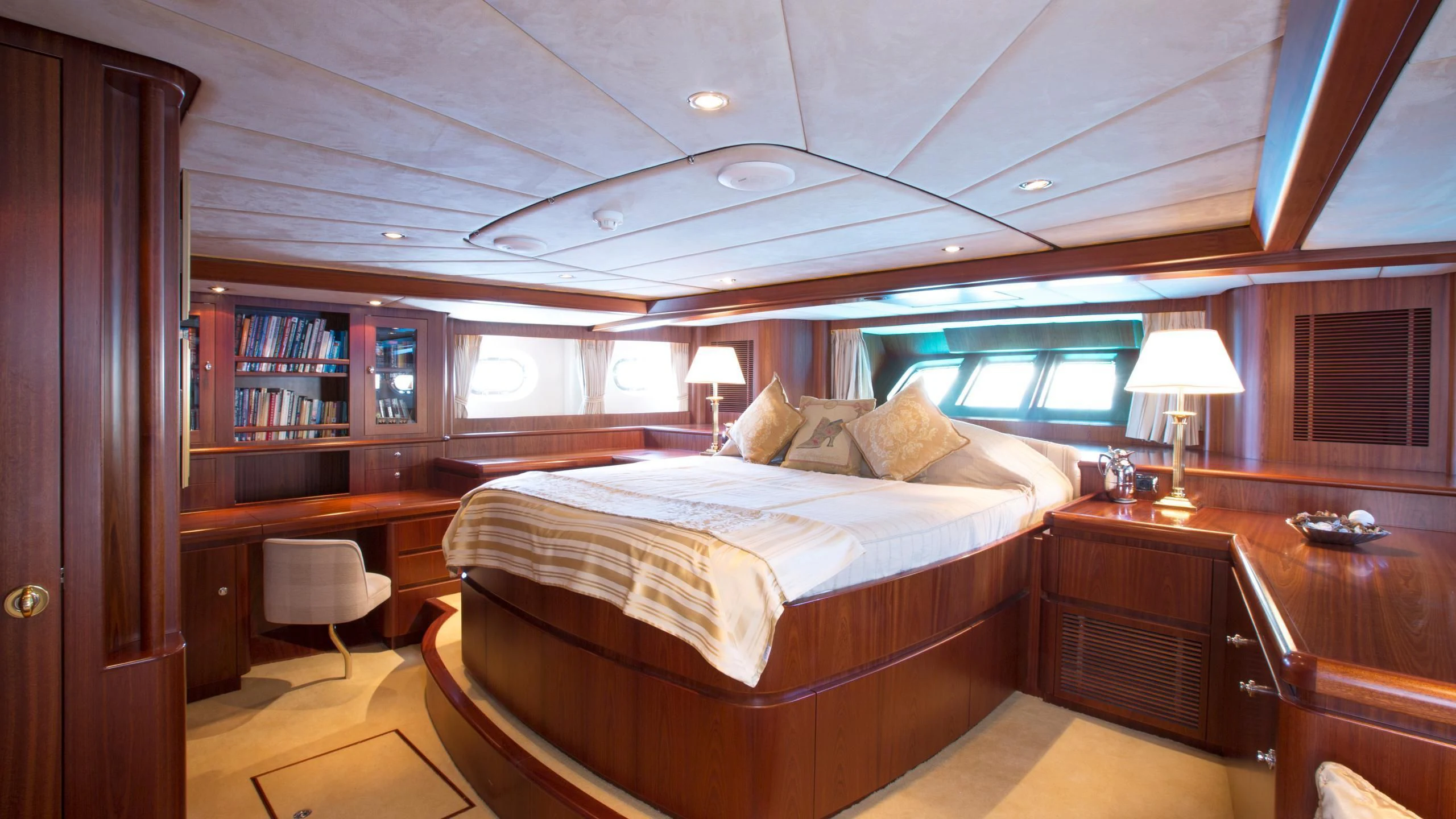 a bedroom with a bed and a desk aboard INFATUATION Yacht for Sale