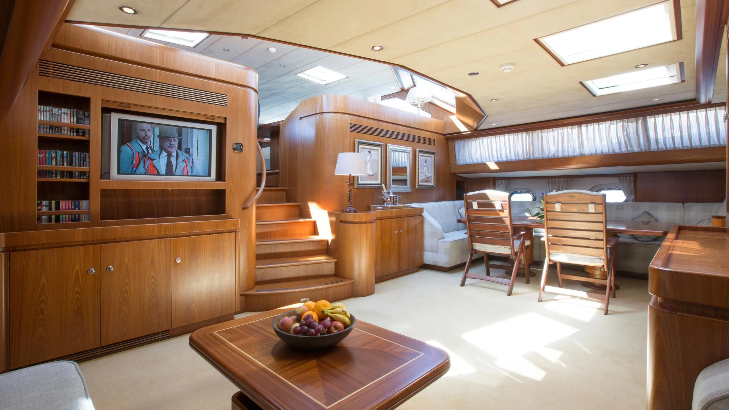 a room with a tv and a table and chairs aboard INFATUATION Yacht for Sale