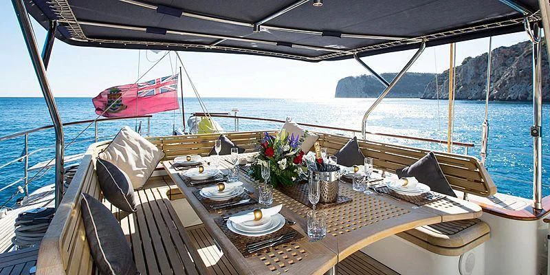 a table with plates and flowers on it on a boat aboard INFATUATION Yacht for Sale