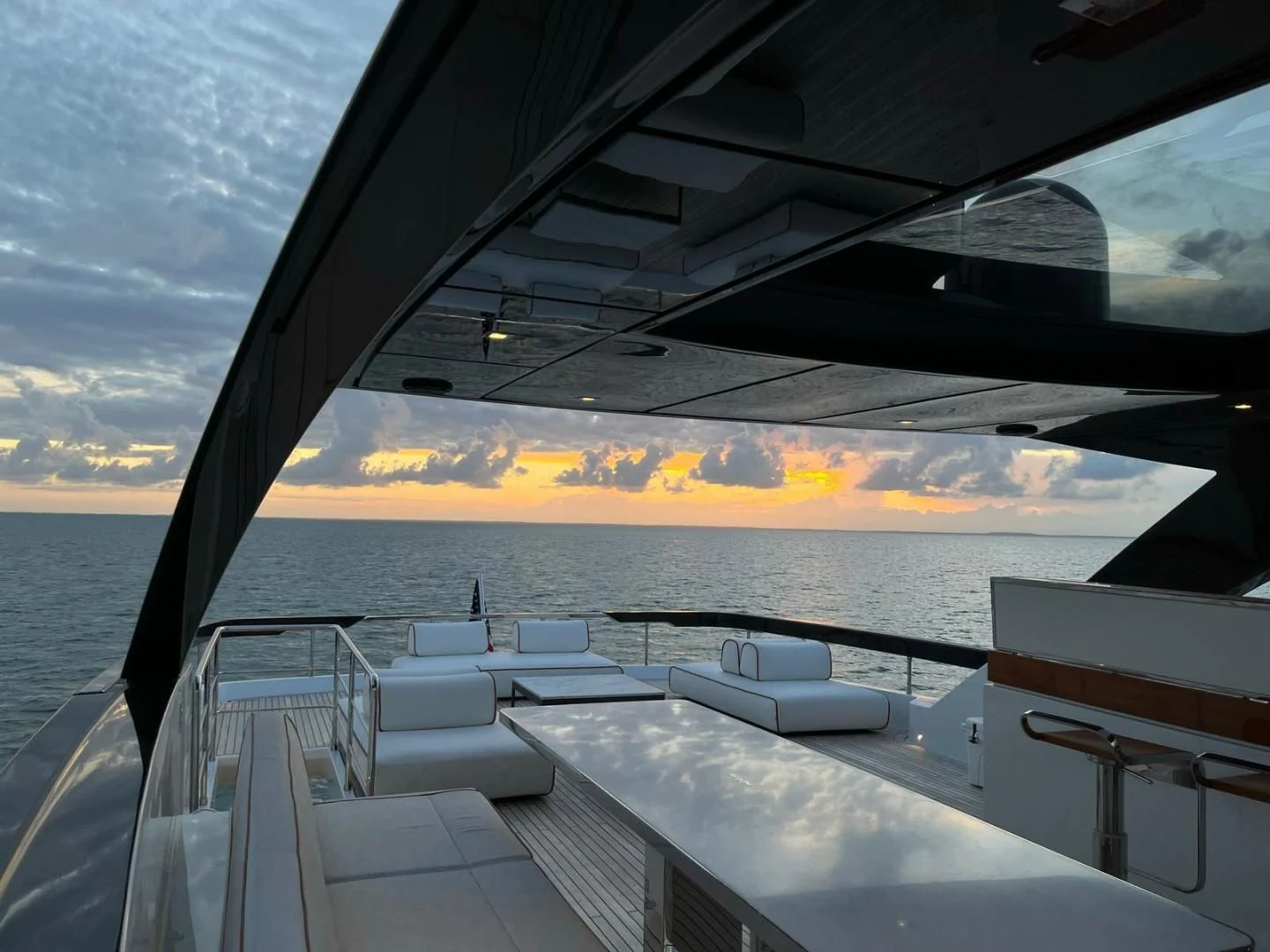 a deck with a view of the sunset and the ocean aboard KIYOMIZU Yacht for Sale
