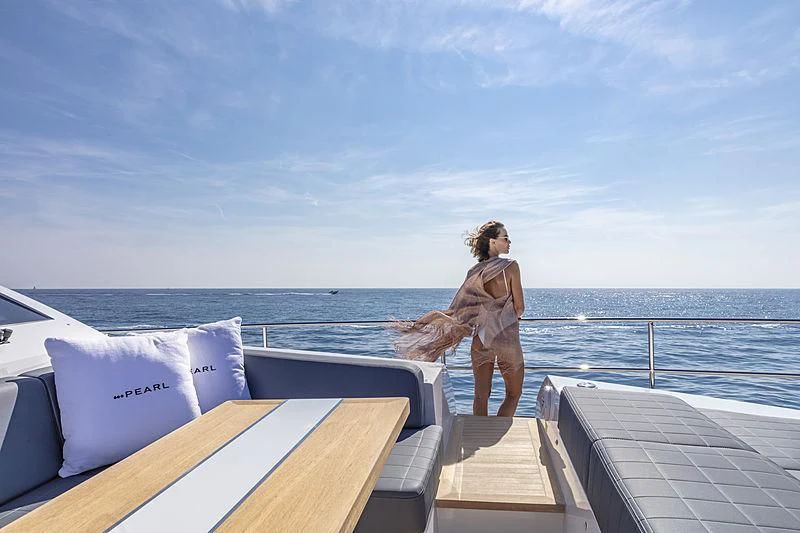 a person sitting on a deck overlooking the ocean aboard AMIRA Yacht for Sale