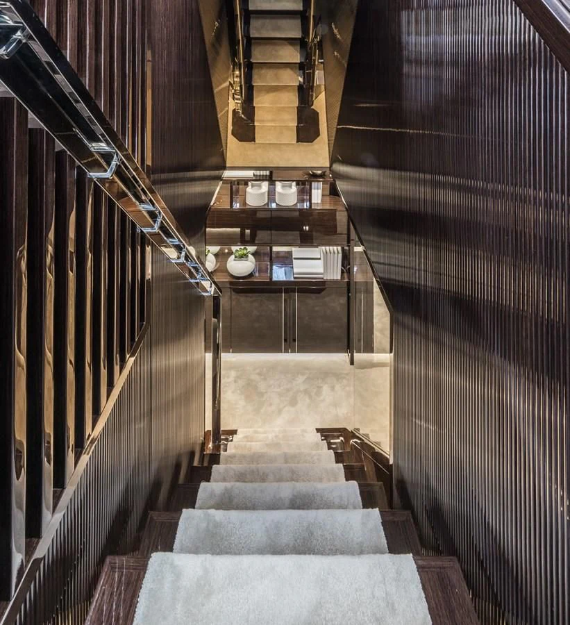 a long hallway with black and white striped walls aboard AMIRA Yacht for Sale