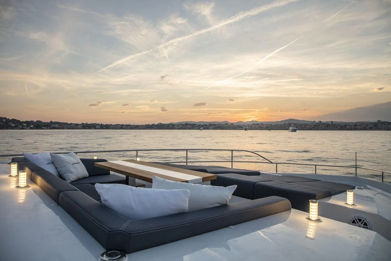 a rooftop with a view of a body of water and a city in the background aboard AMIRA Yacht for Sale