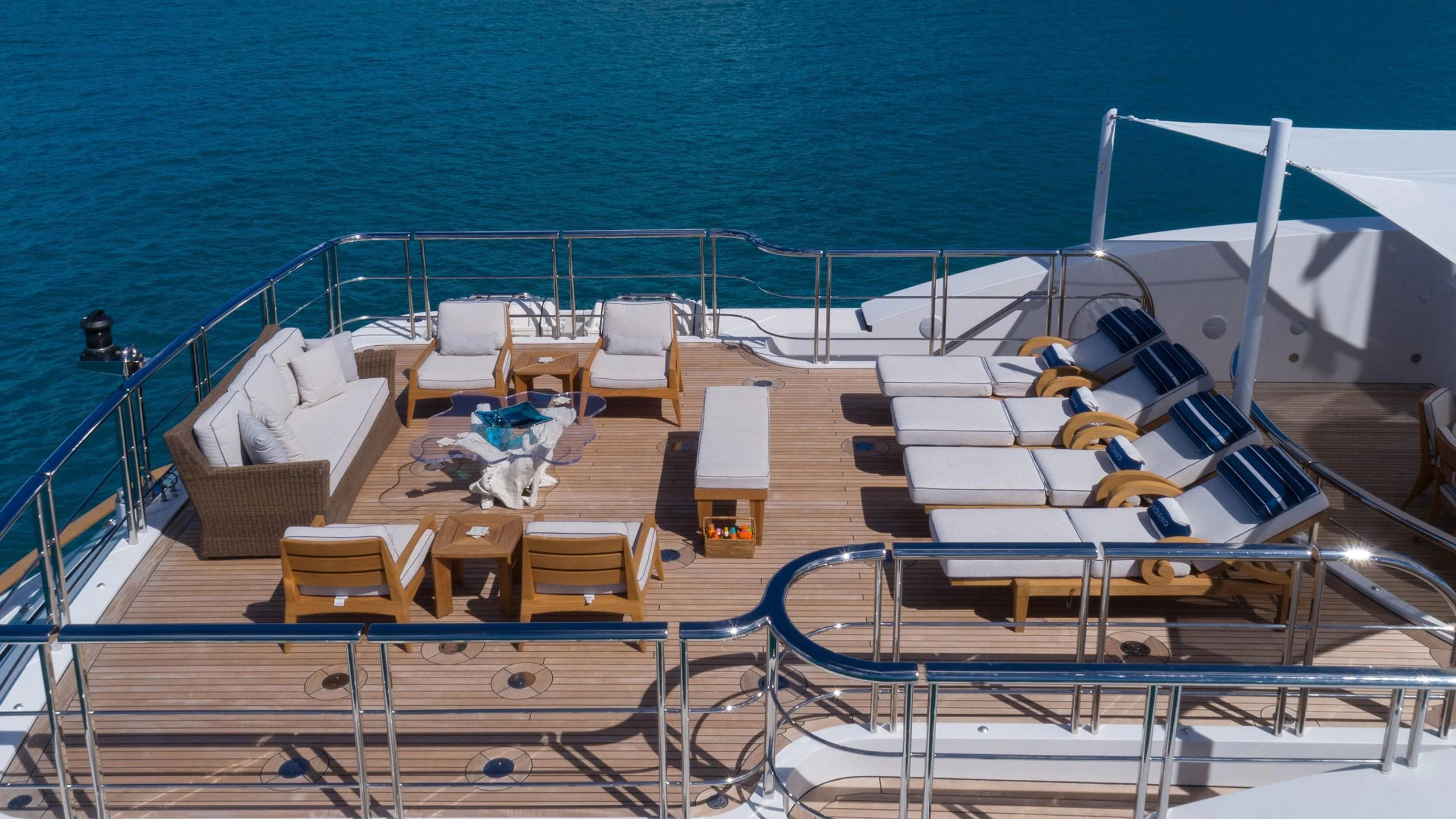 a deck with lounge chairs and umbrellas on it aboard ANDIAMO Yacht for Sale