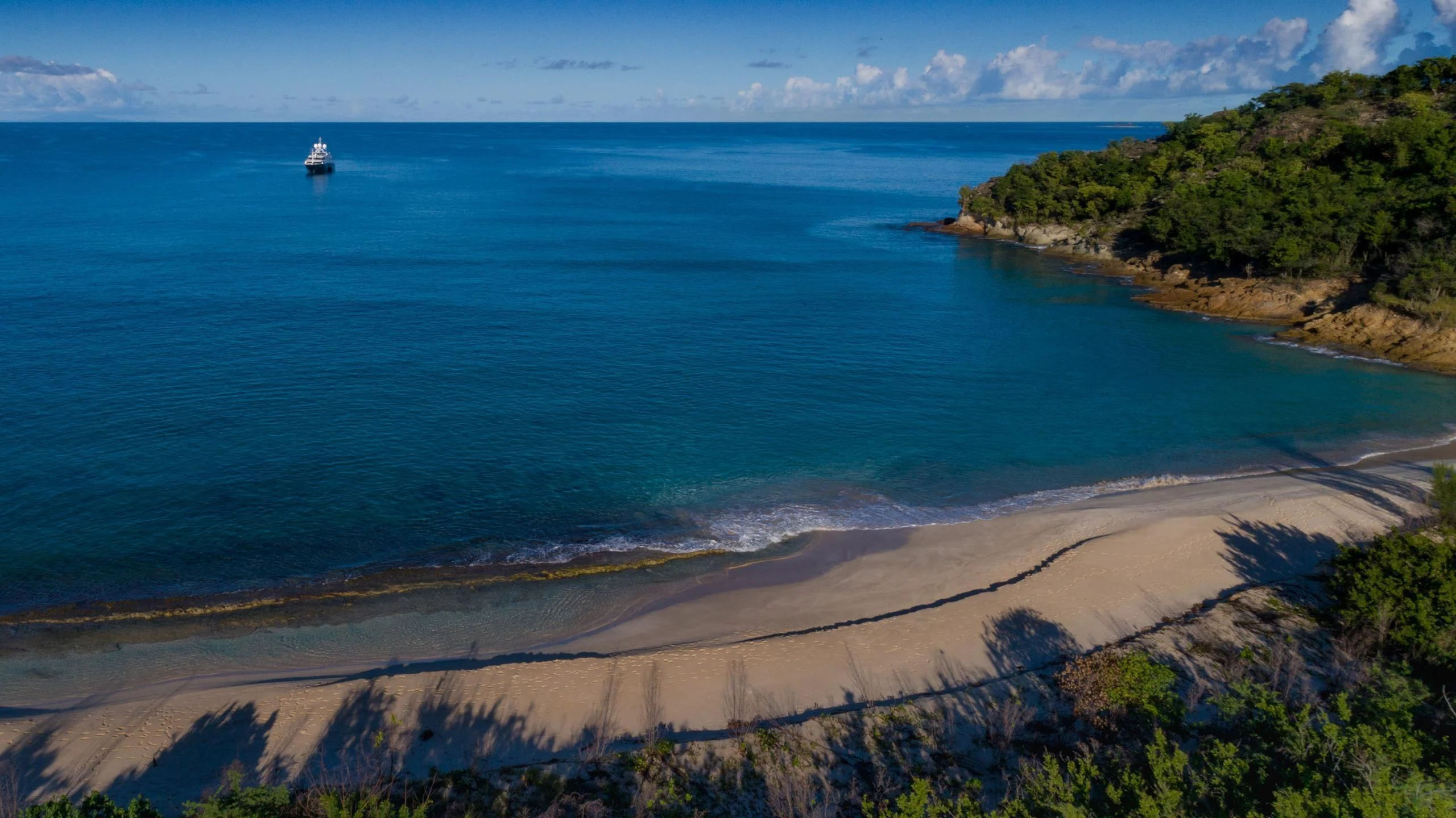 a beach with a boat in the water aboard ANDIAMO Yacht for Sale