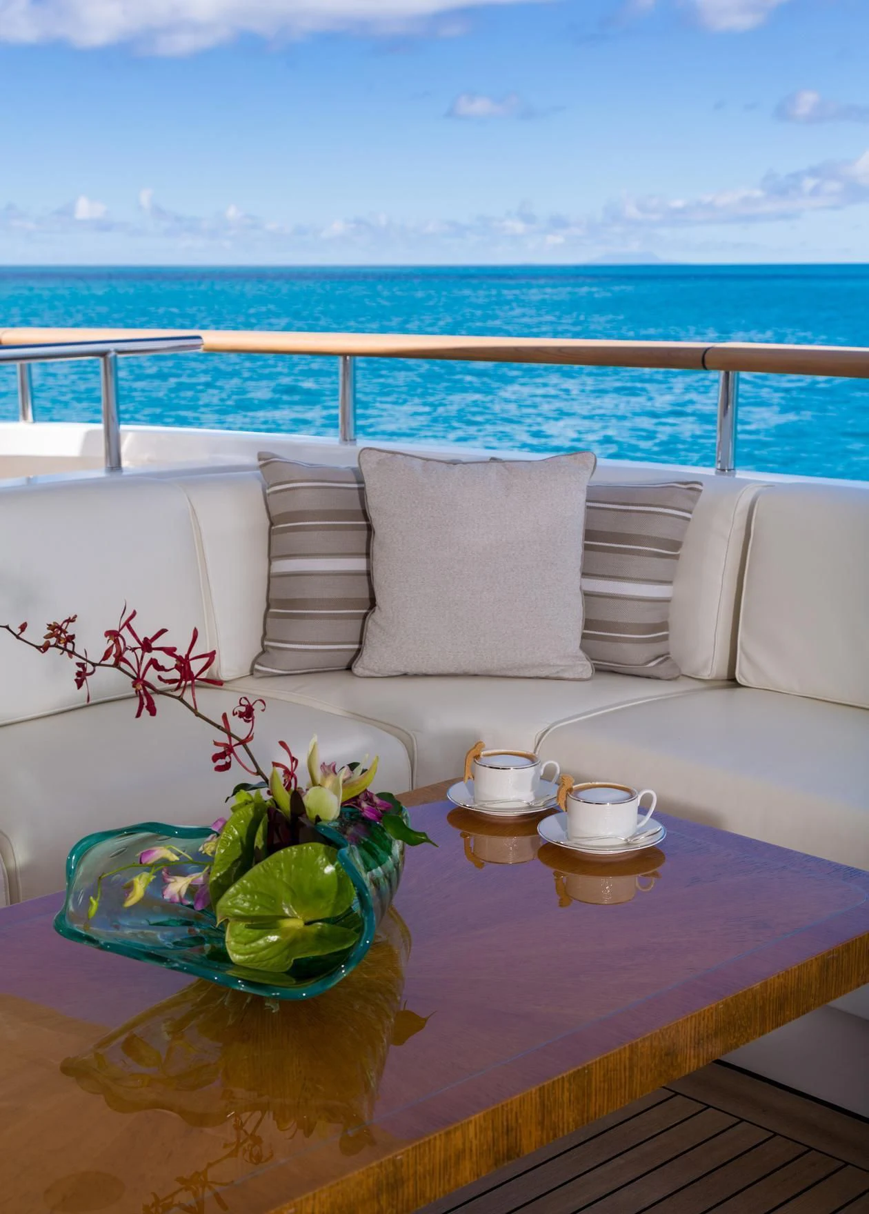 a table with a vase of flowers and a cup of tea on it aboard ANDIAMO Yacht for Sale